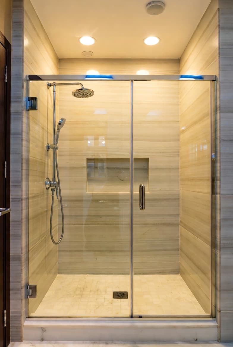 Modern walk-in shower conversion with glass doors and tile surround